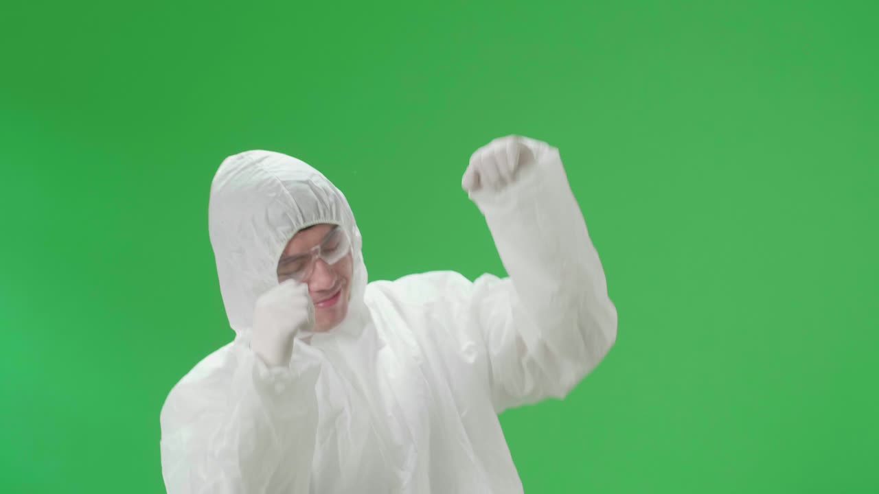 Asian Male Wearing Personal Protective Equipment Uniform Ppe And Dancing In Green Screen Studio