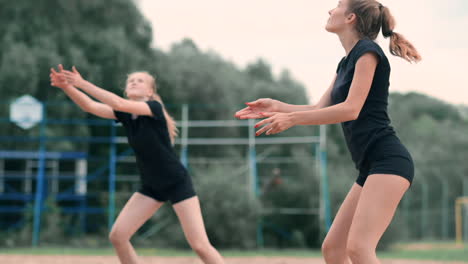 mujeres compitiendo en un torneo profesional de voleibol de playa. un defensor intenta detener un tiro durante el voleibol internacional profesional de playa de 2 mujeres.
