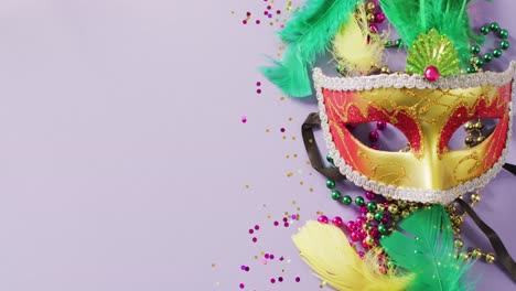 video of carnival masquerade mask, feathers, confetti and mardi gras beads, with copy space