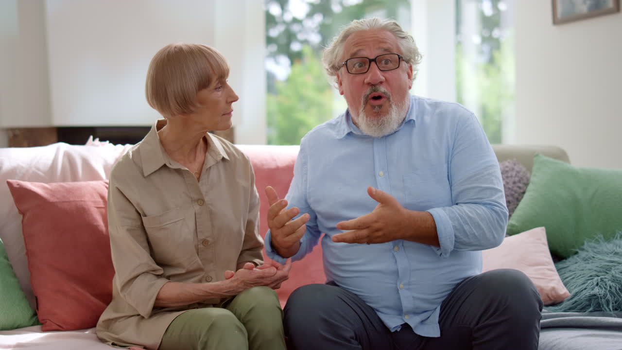 Mujer y hombre hablando en una habitación. Abuelos saludando a los nietos en casa.