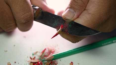 Footage-of-hands-slowly-sharpening-a-pencil-and-some-coloured-pencils-with-a-sharp-knife