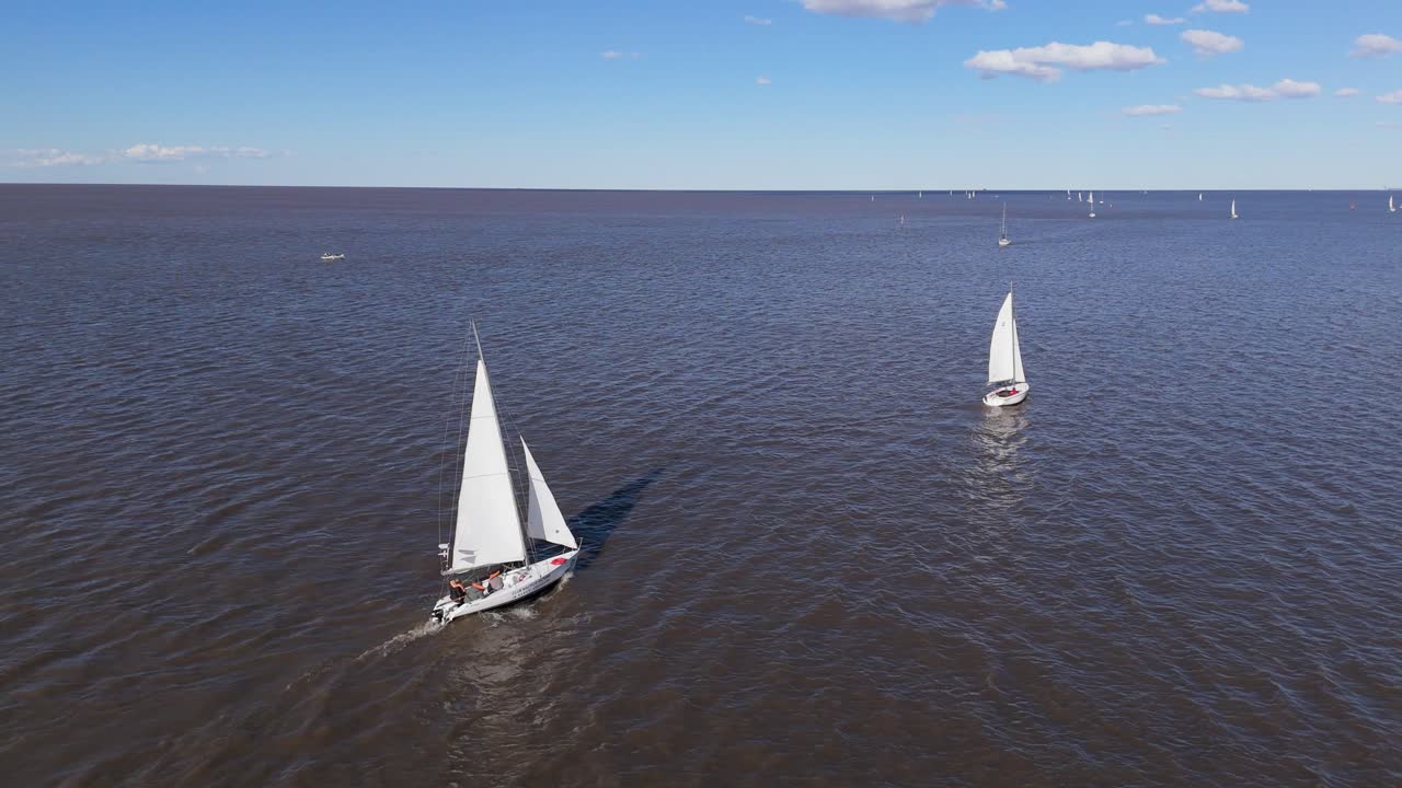 Windsurfers glide on Rio De La Plata on a sunny, clear day