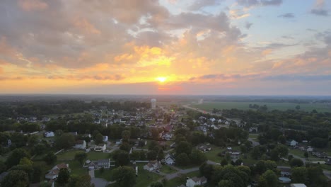 orbit aerial shot of the watertower far away in clarksville with beautiful sunrise at background