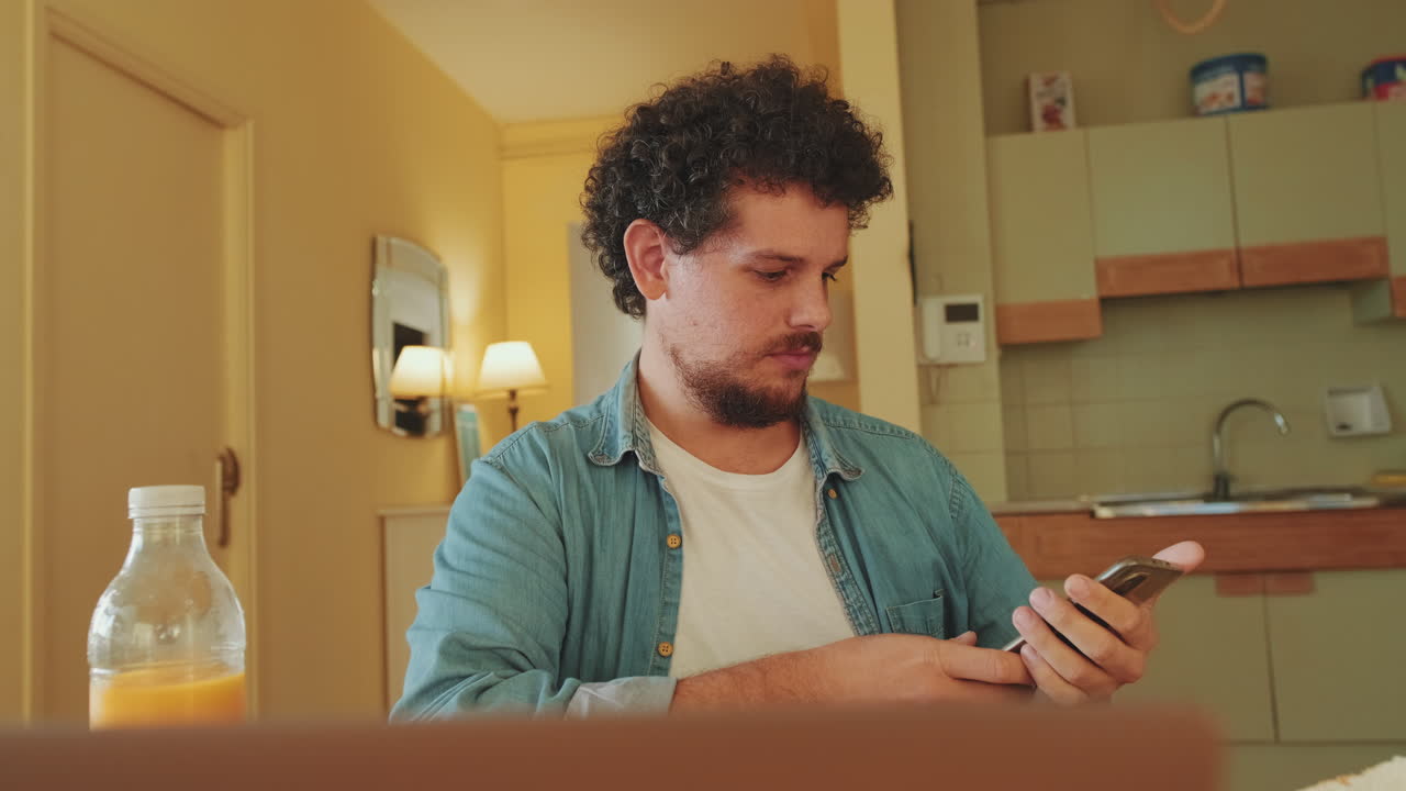 Uomo che utilizza uno smartphone in cucina