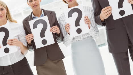 grupo confuso de hombres y mujeres de negocios caucásicos con signos de interrogación