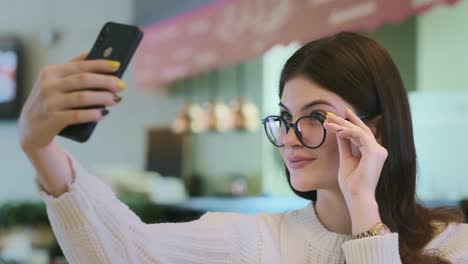 una mujer tomando una selfie en un café.