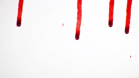 blood droplets on white background dripping down white surface