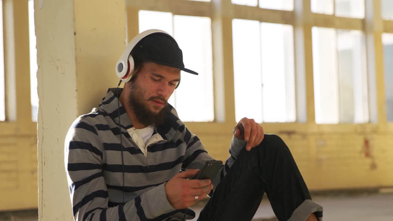 Jovem ouvindo música em um armazém vazio