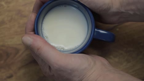 hand holding mug of milk flat lay close up