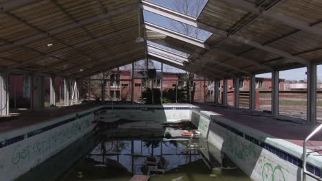 aerial drone footage dollying backwards over an abandoned covered pool