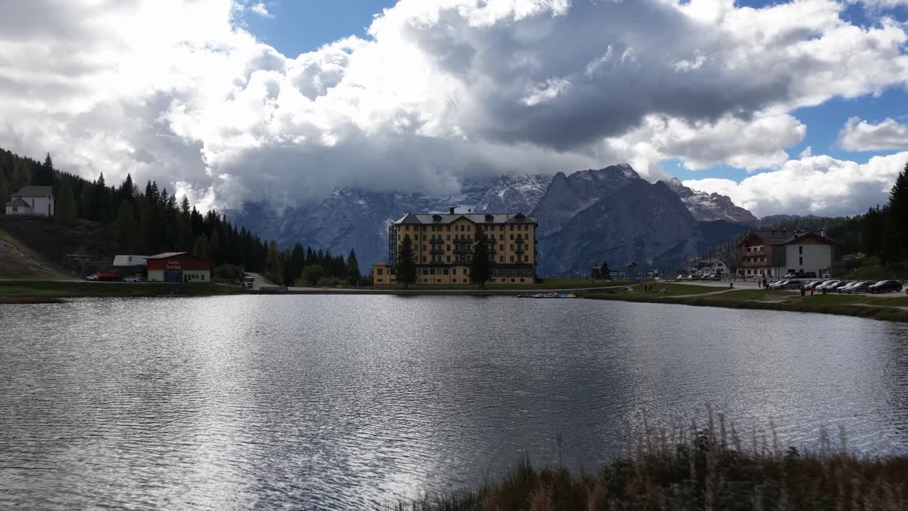 Lake Misurina, the romantic heart of the Dolomites, crystal clear waters reflect the majestic peaks that surround it, such as the Sorapiss group. Aerial drone video, daytime