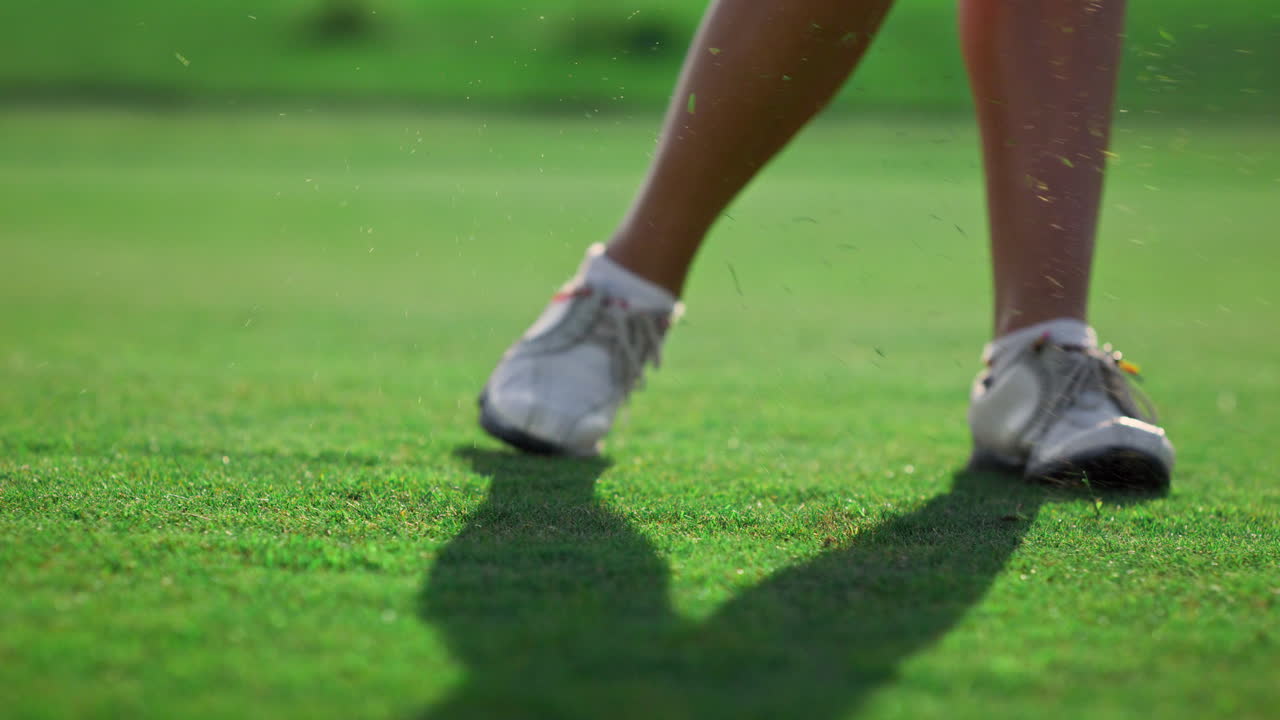 una deportista sana juega al golf en un campo verde. un golfista golpeando la pelota afuera