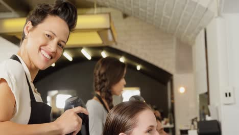 female hairdresser blow drying her client hair