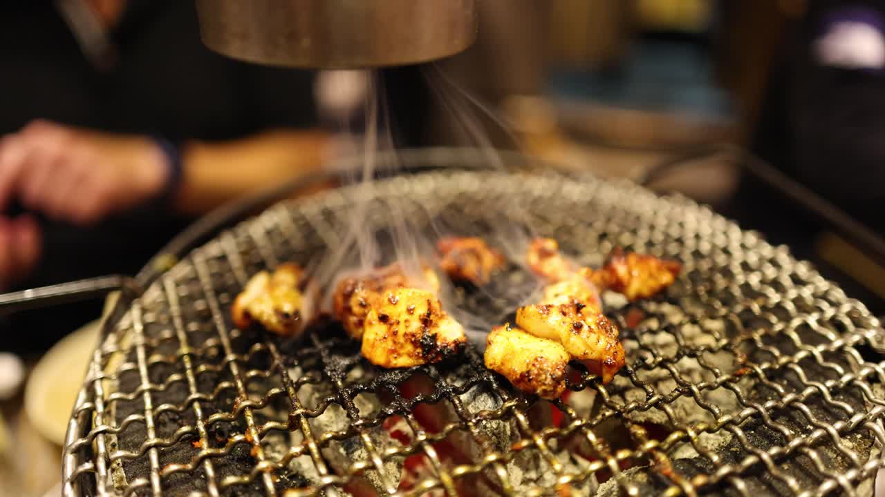 Cooking skewered food on a charcoal grill