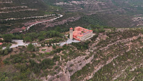 aerial panoramic shot skillfully capturing a monastery nestled amidst the embrace of lush green mountains