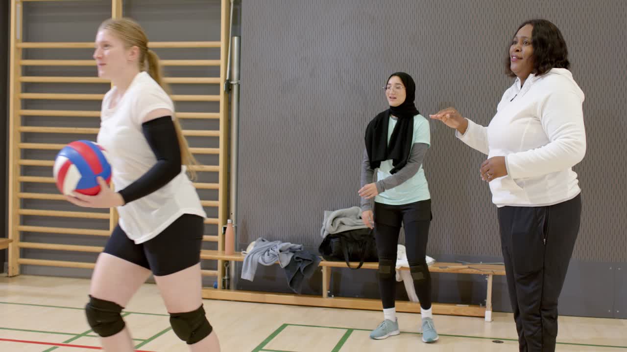 Kuntosalivalmentaja antaa lähtömerkin. Intialainen pikajuoksija antaa yläfemman monimuotoisille joukkuetovereille, jotka harjoittelevat taputtaen.