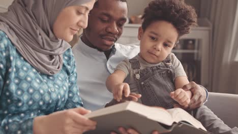 little boy learning about quran from interracial muslim parents