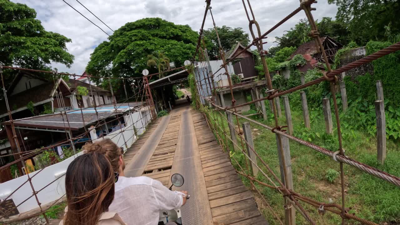 Past timber planks with metal cord they glide, on an exotic scooter ride