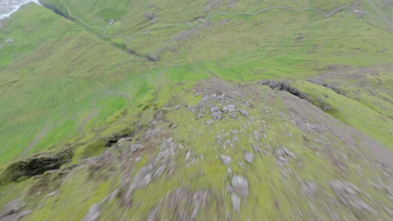 Faroe islands' lush green cliffs, remote beauty, and winding roads, aerial view