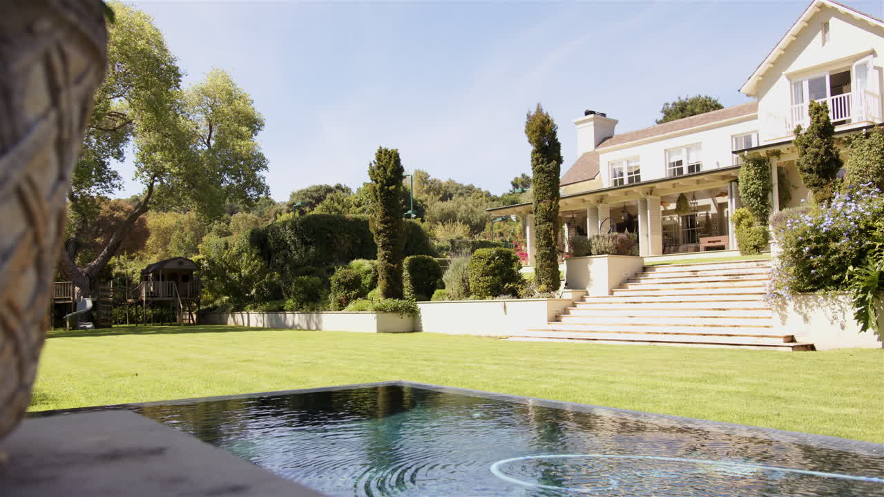 Luxurious house with large garden and swimming pool on sunny day