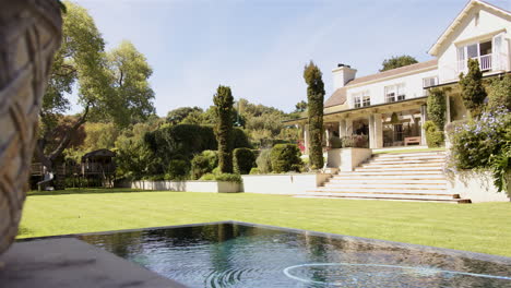 luxurious house with large garden and swimming pool on sunny day