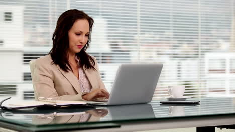 mujer de negocios escribiendo en su computadora portátil