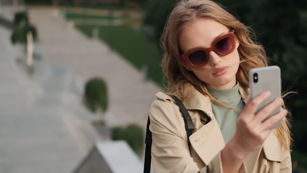 백인 여성 학생이 야외에서 셀카를 찍고 있습니다.