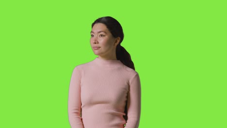 Studio-Portrait-Of-Woman-Looking-All-Around-Frame-Against-Green-Screen