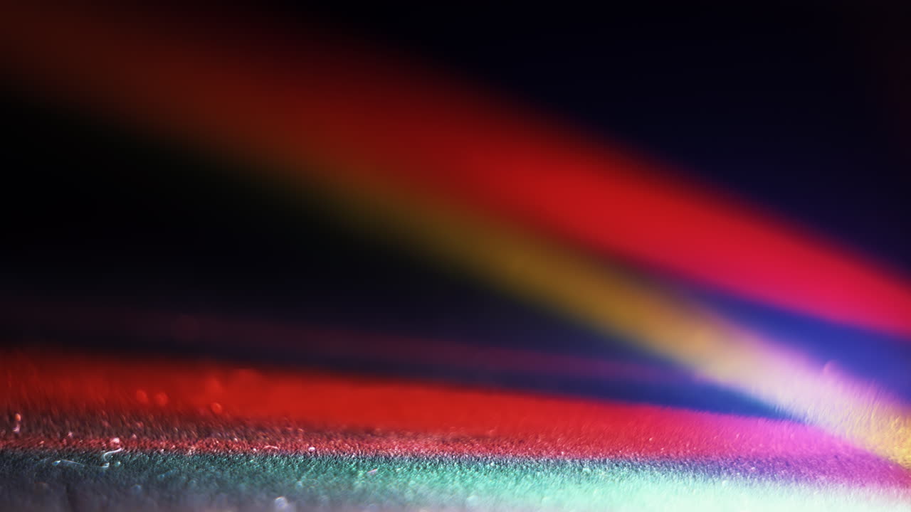 textura de fondo abstracta y colorida con luces parpadeantes de los reflejos de los rayos de luz de un cristal que gira y cambia de color sobre un fondo negro