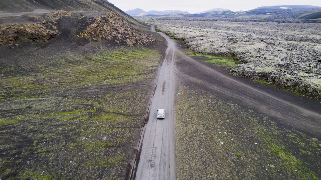 Auto che guida attraverso il paesaggio unico ed extraterrestre dell'Islanda.