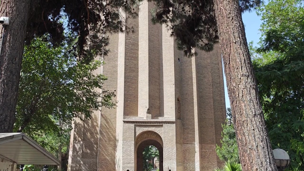 Antica torre di mattoni circondata da alberi in un parco
