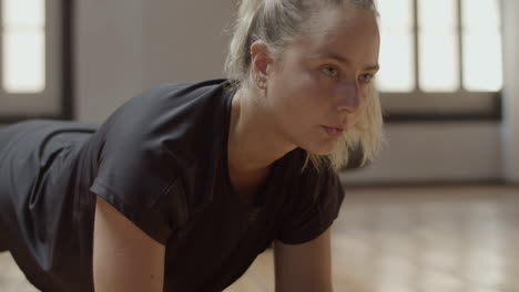 close-up shot of hard-breathing woman standing in plank position