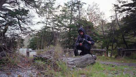 tourist sits by snowy lakeside in bariloche, argentina, enjoying traditional yerba mate