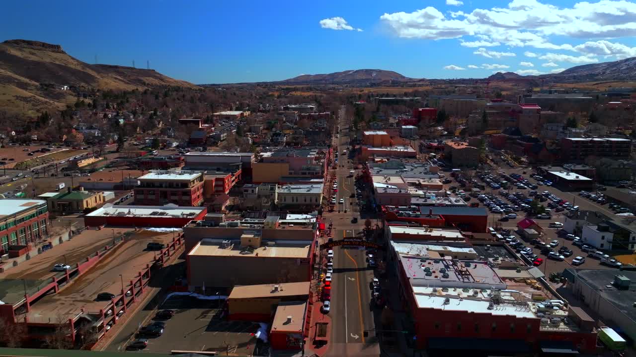 Welcome to historic downtown Golden Colorado aerial drone North Table Mountain Mesa Golden Gate Canyon winter sunny morning afternoon blue sky businesses buildings cars School of Mines forward