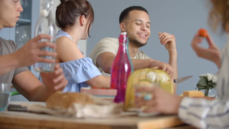 amigos adultos jóvenes bebiendo y comiendo en una mesa de comidas de amigos