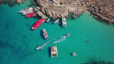 fotografía aérea de barcos y transbordadores turísticos que llegan y salen de la laguna azul, isla de comino, malta