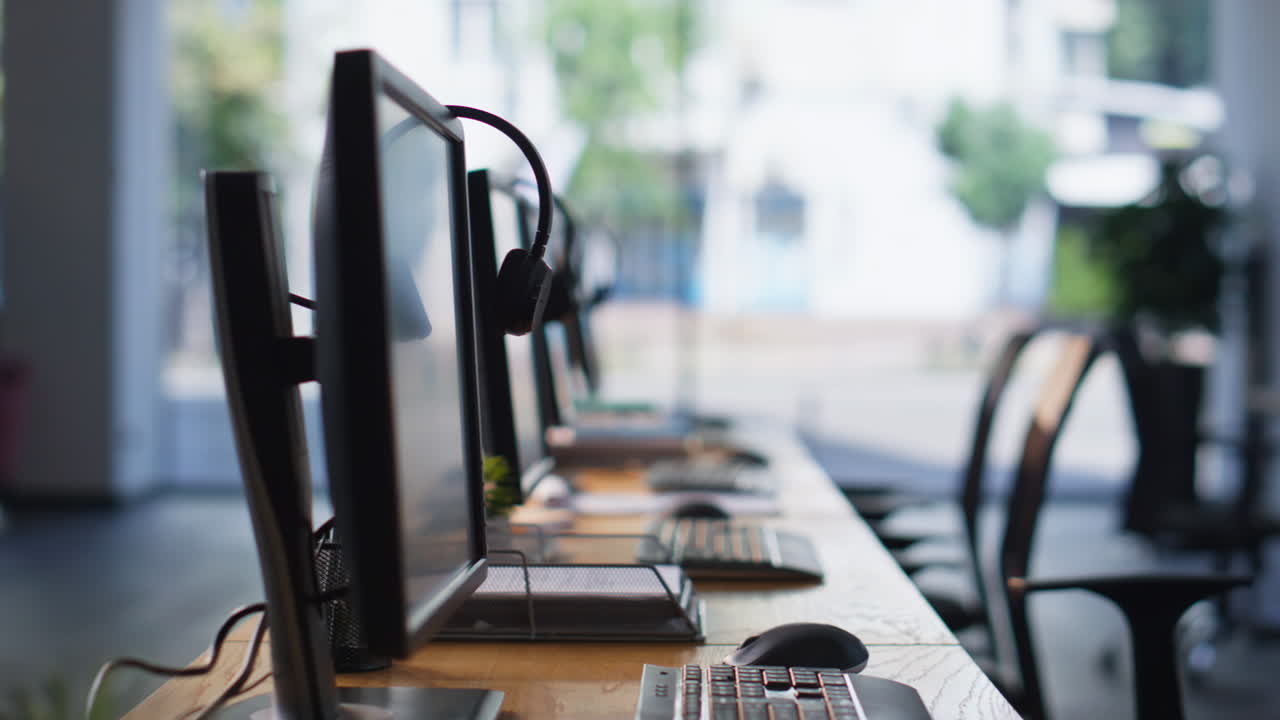 Empty office desks computers and headphones at workspace. Organized call center