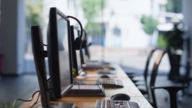 Empty office desks computers and headphones at workspace. Organized call center