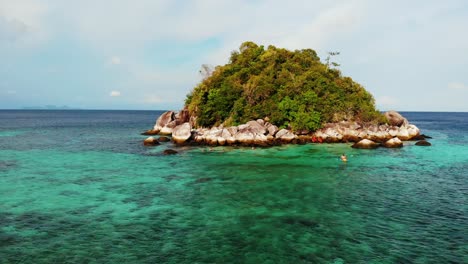 vista aérea de personas buceando y navegando en kayak por una isla tropical rocosa