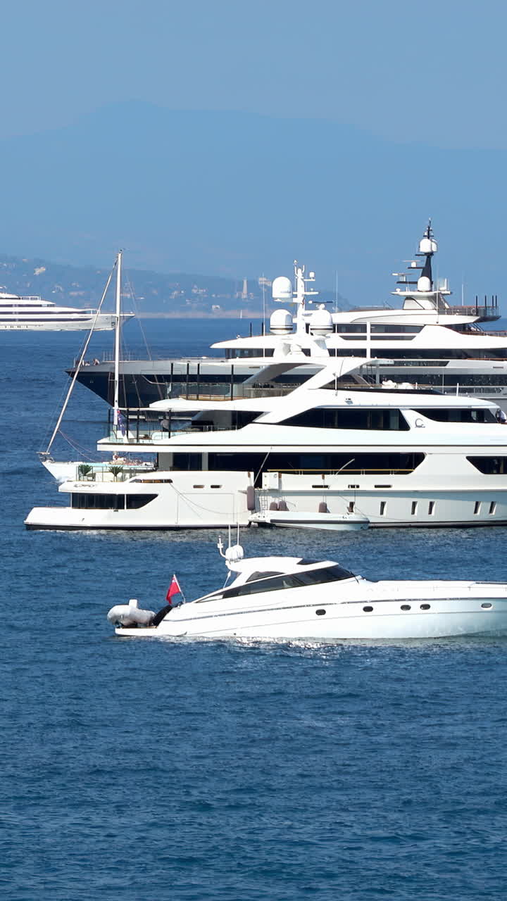 White boats moving on the sea in Antibes, France. Vertical