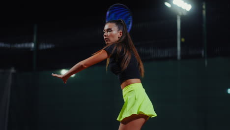 woman playing tennis at night