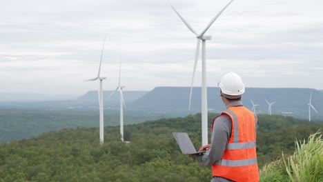 progressive concept of engineer working in the wind farm atop of the mountain.