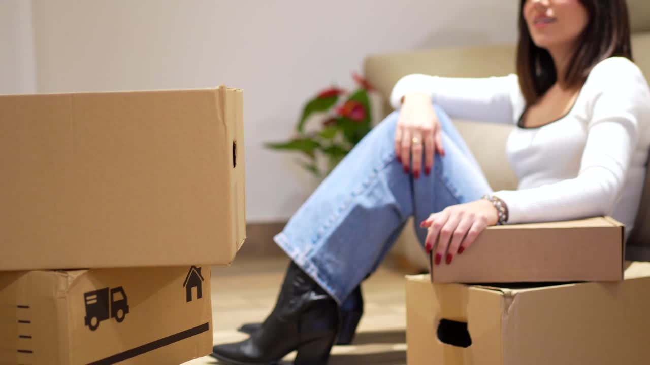 Woman taking a break from unpacking moving boxes