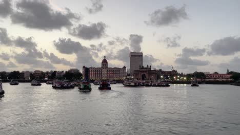 boats docked near the iconic gateway of india, with clouds overhead.