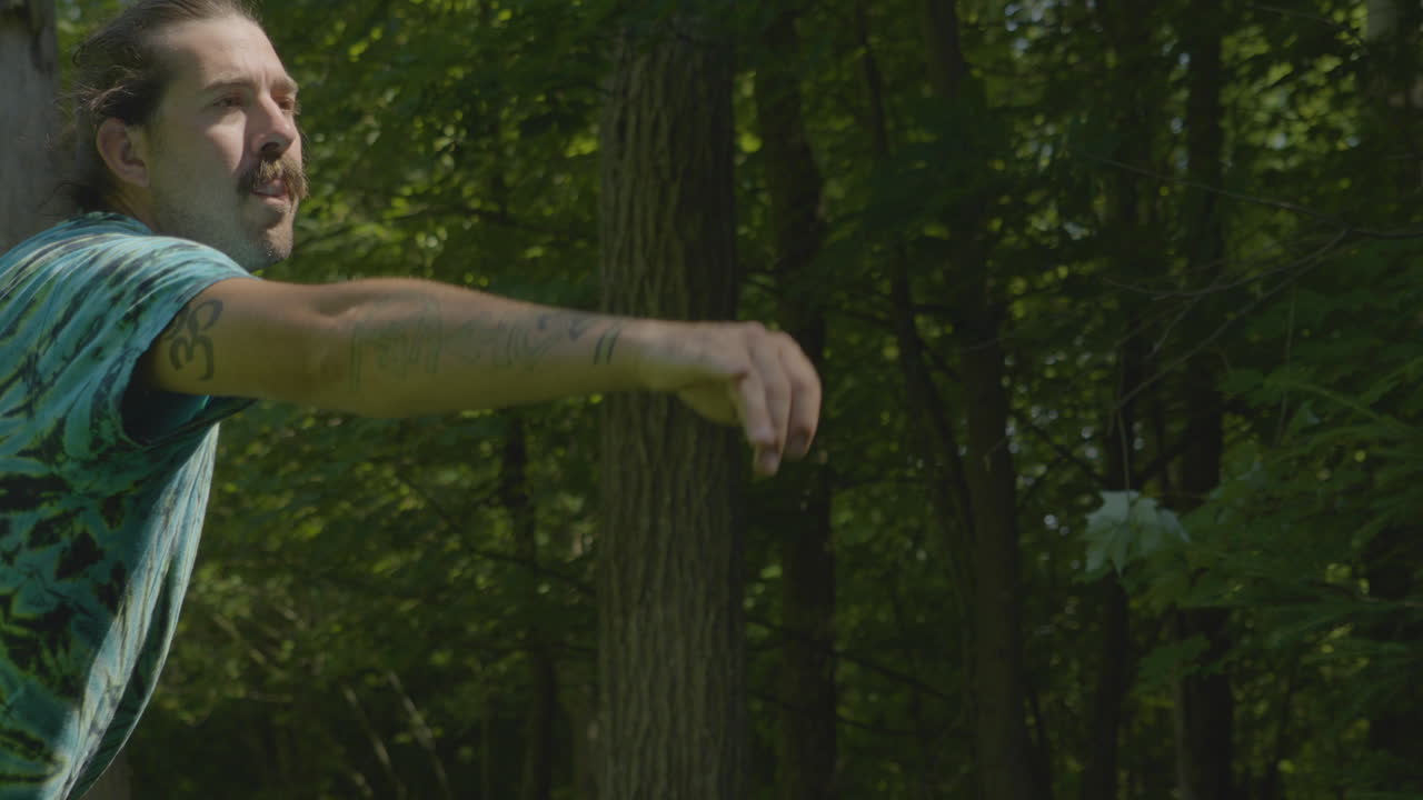 Man Playing Disc Golf in the Woods