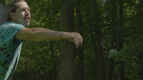 man playing disc golf in the woods