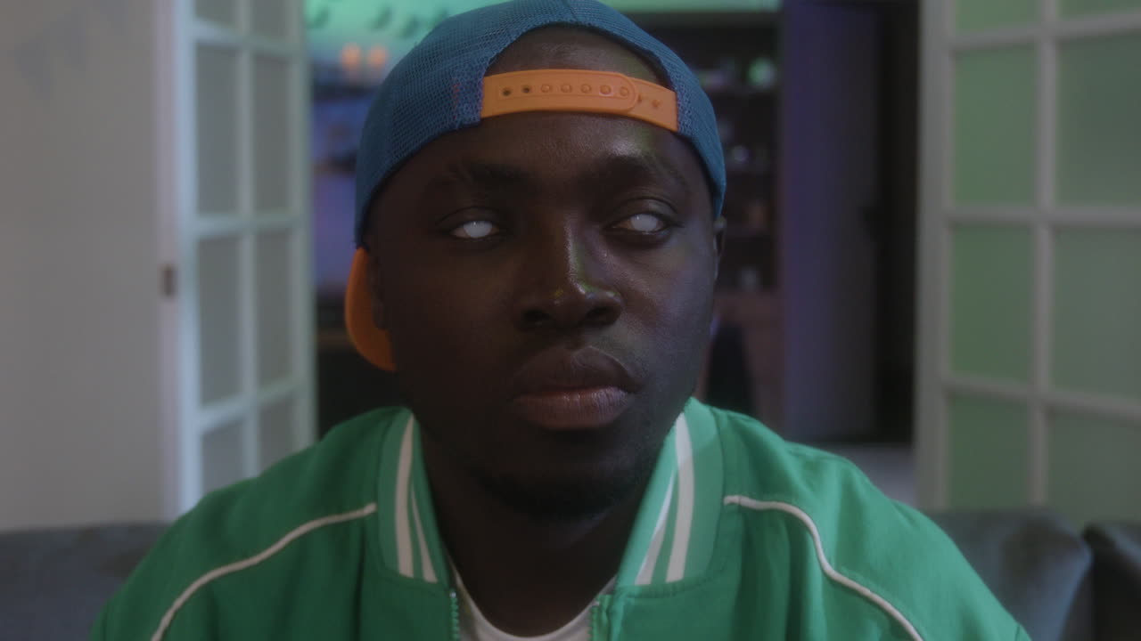 Portrait of a man with white eyes wearing a baseball cap