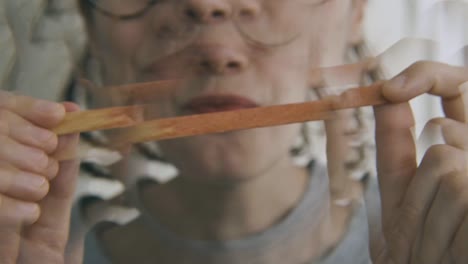 a girl has just finished eating a popsicle and shows the empty stick happy, slow motion, interior, detail