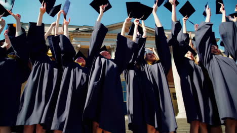 university graduates celebrating and throwing caps in the air