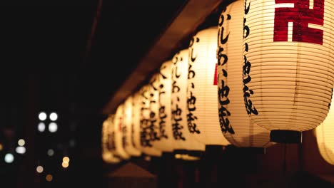 a sequence of traditional lanterns glowing in darkness